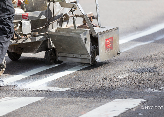 Image of new pavement markings being installed on the roadway.
