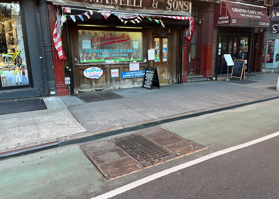 Image of a transformer vault in a bike lane within the roadway