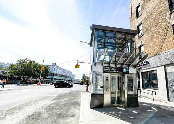 Image with a portion of roadway and sidewalk showing with an MTA elevator at the curb