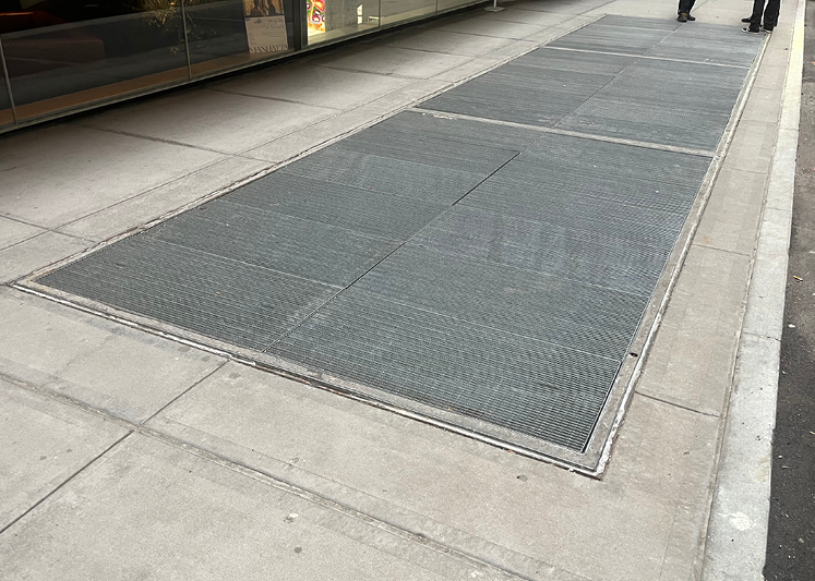 Photo of ventilator grates on a sidewalk.