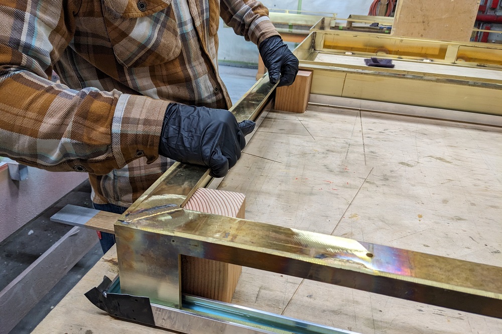 A person builds a metal frame for the floor of a cafe