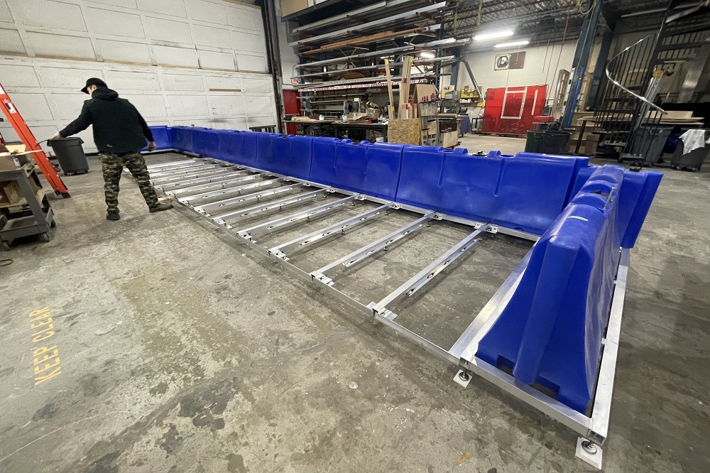 Inside a studio a person assembles barriers on top of a metal frame